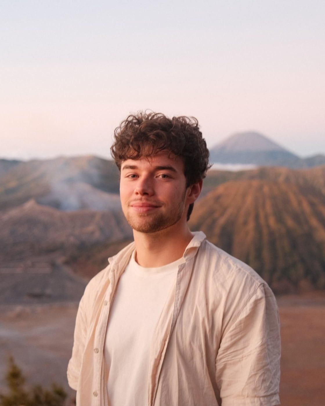 Huub, de maker van Northline Digital, glimlachend in een licht linnen overhemd, met een berglandschap op de achtergrond